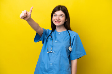 Young surgeon doctor Russian woman isolated on yellow background giving a thumbs up gesture