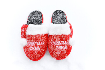 Red home Christmas slippers on the snow in winter.