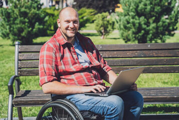Obraz premium Freelancer with a physical disability who uses wheelchair working at the park