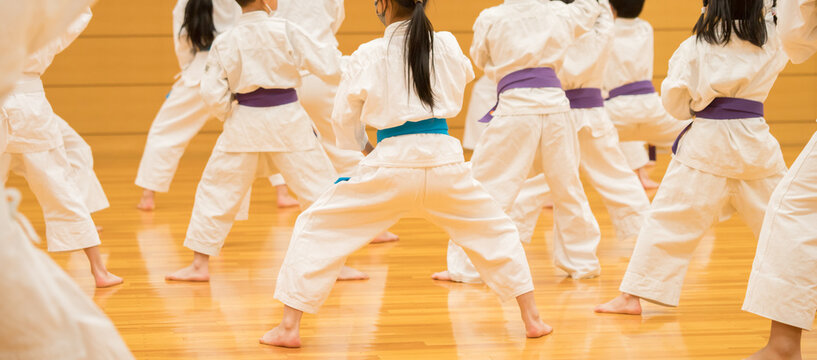 教室で空手を練習している小学生たちの姿