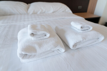 Obraz na płótnie Canvas Stack towel set on bed in modern bedroom at hotel