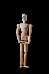 Wooden mannequin with a QR code on a dark background. Selective focus. The concept of the trend of assigning QR codes to people in connection with countering the new Covid virus infection.