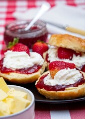 Close-up of scones with strawberry jam, cream and fresh strawberries