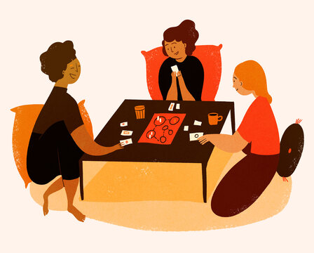 Three people sitting at table playing board games