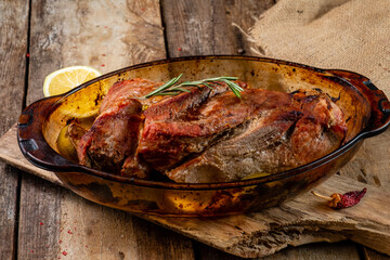 A large piece of baked pork on a wooden table.