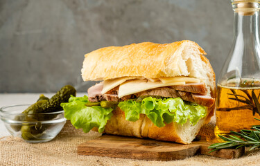 Large sandwich with pork and pickled cucumber.