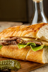 Homemade Cuban sandwich with pork, cheese and vegetables. Vertical photo, selective focus.