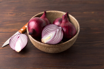 Organic red onions on a wooden background, fresh raw vegetables.