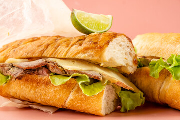Sandwich cubano traditional fast food on a pink bright background, close-up.