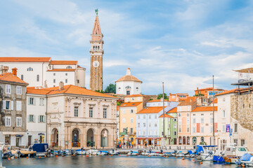 Fototapeta premium View on the Venetian style Piran main square with colorful historical houses and dominant church tower from a pier, Piran, Slovenia