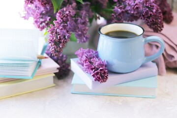 Books, notepads and fresh lilac flowers on the table by the window, the concept of education, home reading, learning, back to school, spring, vacation