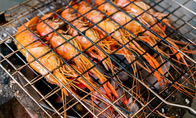 Grilled prawn on charcoal grill. Giant freshwater prawns grill on a flaming charcoal fire. Closeup...