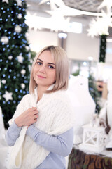 Portrait of a girl with blond hair on the background of a Christmas tree. Selective focus.