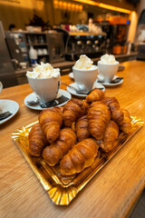 chocolate suizo con nata y cruasanes en cafetería para compartir