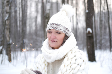 Portrait of a girl holding a burning sparkler candle in her hands.