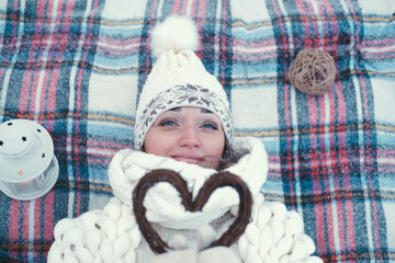 Portrait of a girl holding a handmade wooden Christmas decoration in the shape of a heart.