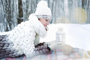 The girl lies on the snow in the winter forest or park. Concept - Christmas vacations and holidays.