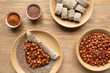 Injera traditional Ethiopian sourdough ferment flatbread with spicy chickpea stew with flaxseed sauce. Top view.