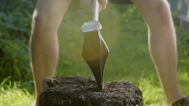 Slow motion wood chopping with an axe. Front view.