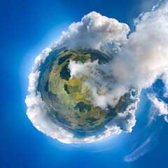 Naklejka premium Aerial view from high altitude of little planet earth covered with white puffy cumulus clouds on sunny day