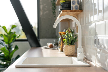 White ceramic sink in white kitchen interior design
