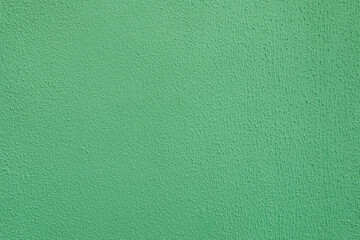 Light green scuffed plaster on concrete wall.