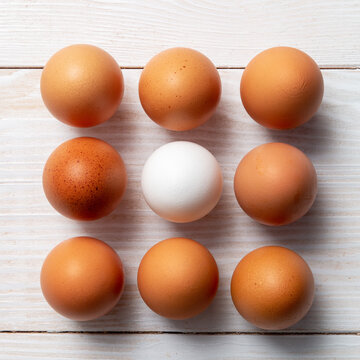 Nine eggs on a wooden background.
