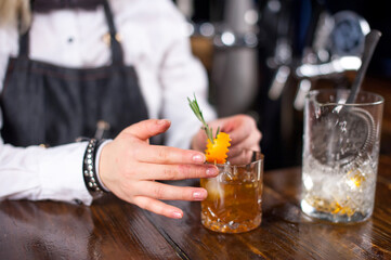 Focused barmaid formulates a cocktail in cocktail bars