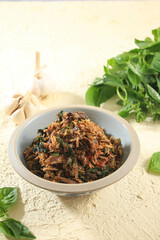 Ikan Tongkol Suwir or Shredded Tuna, Indonesian Fraditional Food, Served in Rustic Bowl with Sweet Basil (Kemangi) Leaves as a Garnish
