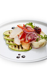 Baked chicken fillet on a pillow of mashed potatoes. Isolated on a black background.