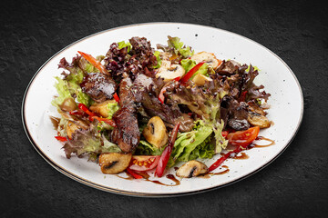 Salad with chicken liver, sweet pepper and champignons. Isolated on a black background.