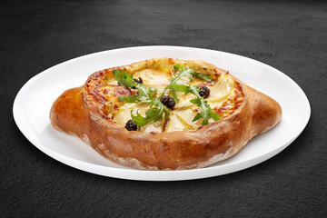 Traditional Georgian cuisine. Adjarian khachapuri. Isolated on a black background.