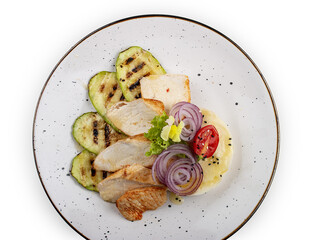 Baked chicken fillet on a pillow of mashed potatoes. Isolated on a white background.