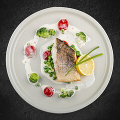 Pike perch on a vegetable pillow . Isolated on a black background.