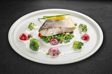 Pike perch on a vegetable pillow . Isolated on a black background.