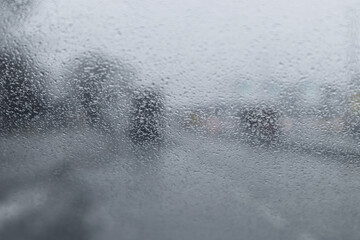 View through the car window in the rain. Wet window with drops