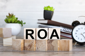 ROA. text on wood blocks near a notebook on a work table
