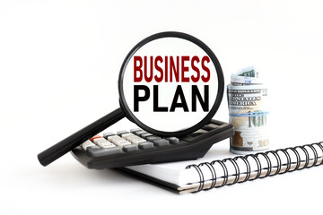 BUSINESS PLAN. white background text on magnifying glass. calculator magnifier