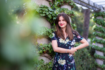 Young woman with stylish clothes posing in a paradisiacal park	