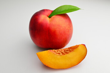 Peach fruit half with leaf isolated on white background. Peach half and slice. 