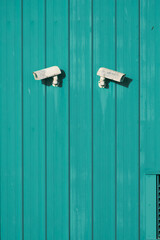 cctv security camera on a green wooden background