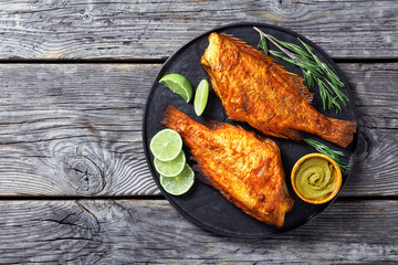 two fried ocean perch with rosemary and lime