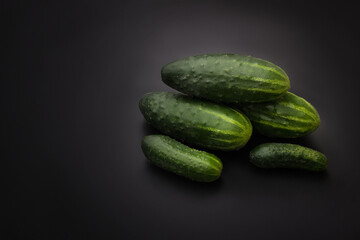 Cucumbers on a black background. Fresh cucumbers. Vegetarian food. Place for text.