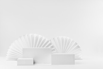 Set of three rectangle white podiums mockup with oriental paper fans as decor in modern minimal...