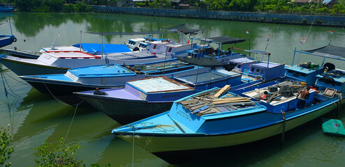 Fototapeta na wymiar Buton, Southeast Sulawesi, INDONESIA December 4, 2021, a row of traditional fishing boats with various colors anchored around the shoreline