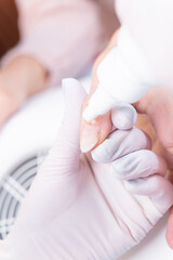 beautican use cuticle softening gel to client's nails.processing of nails. Close-up view.