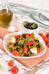 Fusilli pasta with cherry tomatoes, eggs and black olives.
