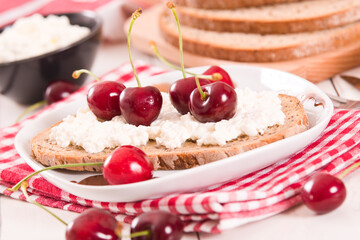 Rye bread with cottage cheese and cherries.