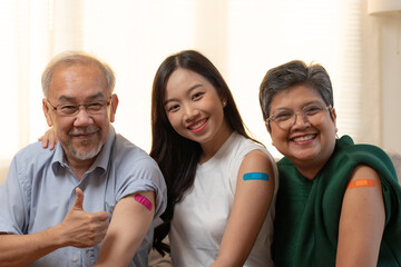 Happy smiling asia family showing arms vaccinated against covid 19