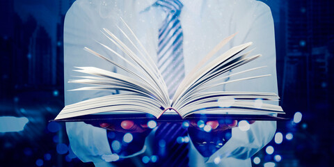 Double exposure of businessman holds open book